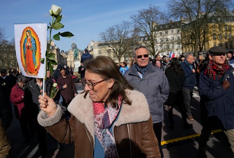 Un activista antiaborto sostiene un cartel que representa a la Virgen María cerca del Palacio de Versalles durante la sesión del Congreso de ambas Cámaras del Parlamento en Versalles, al oeste de París, el lunes 4 de marzo de 2024.