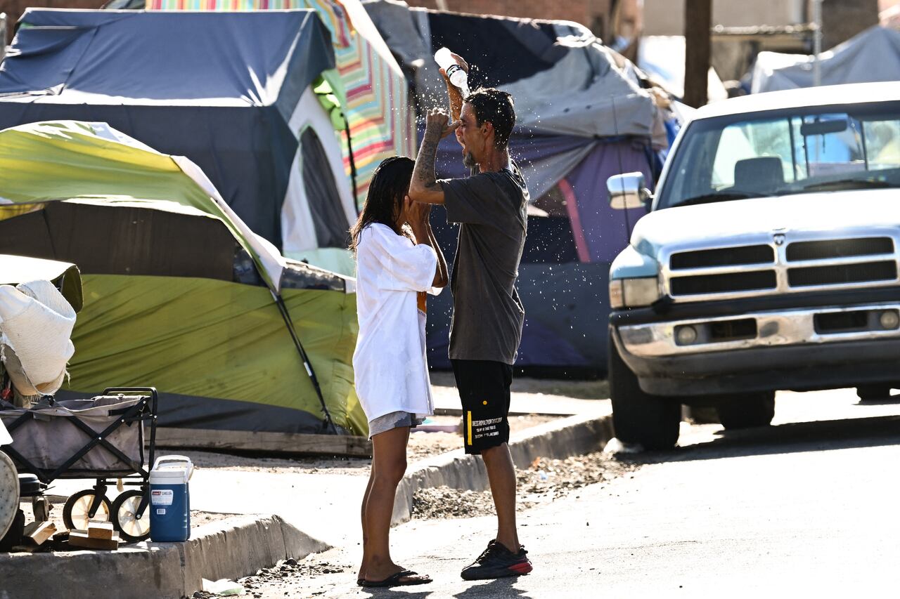 Dos personas en Arizona tratan de refrescarse durante el intenso calor en Estados Unidos.