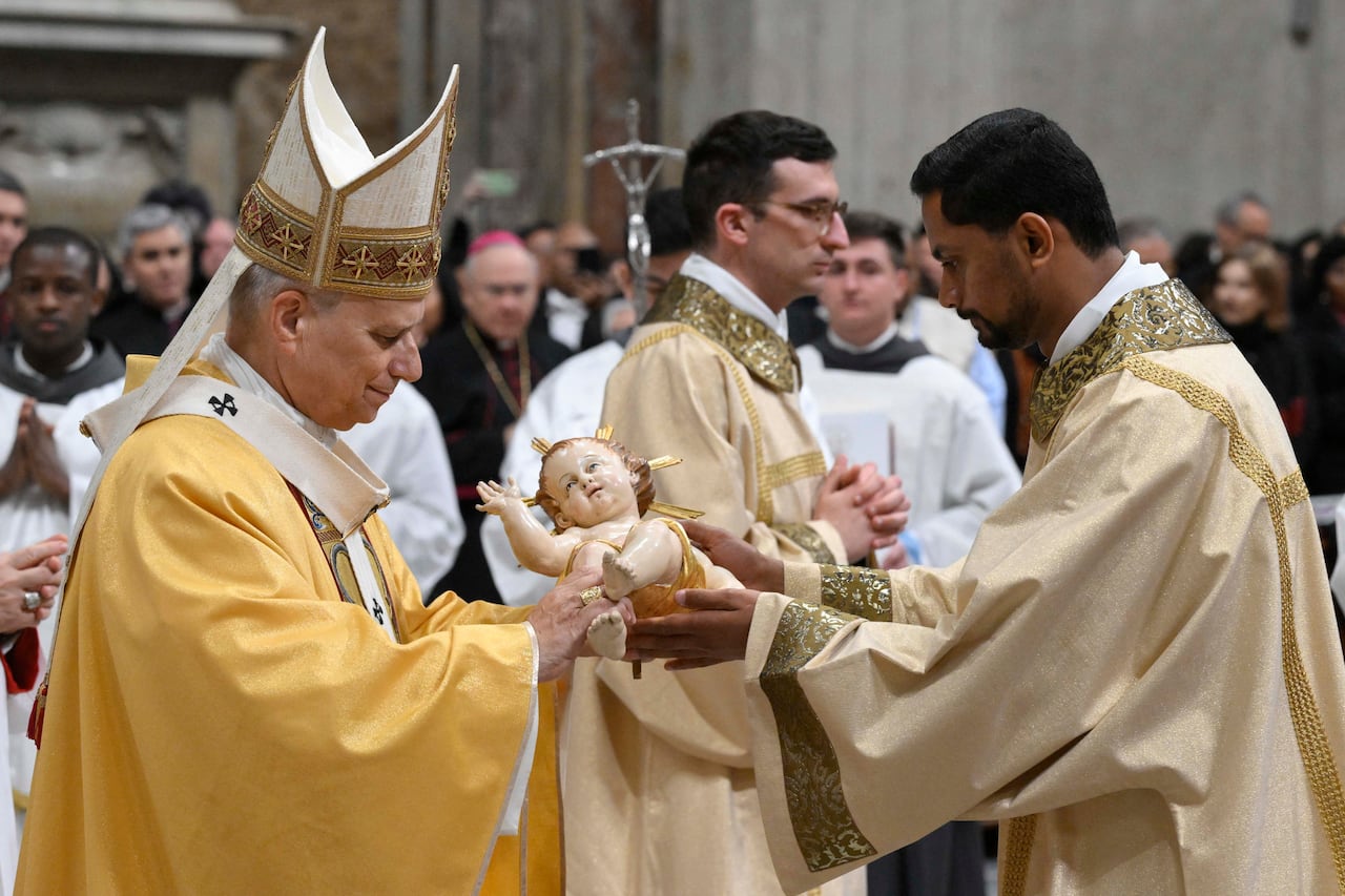 Esta fotografía proporcionada el 24 de diciembre de 2025 por Vatican Media muestra al Papa León XIV recibiendo la estatua del Niño Jesús al final de la misa de Nochebuena en la Basílica de San Pedro en el Vaticano