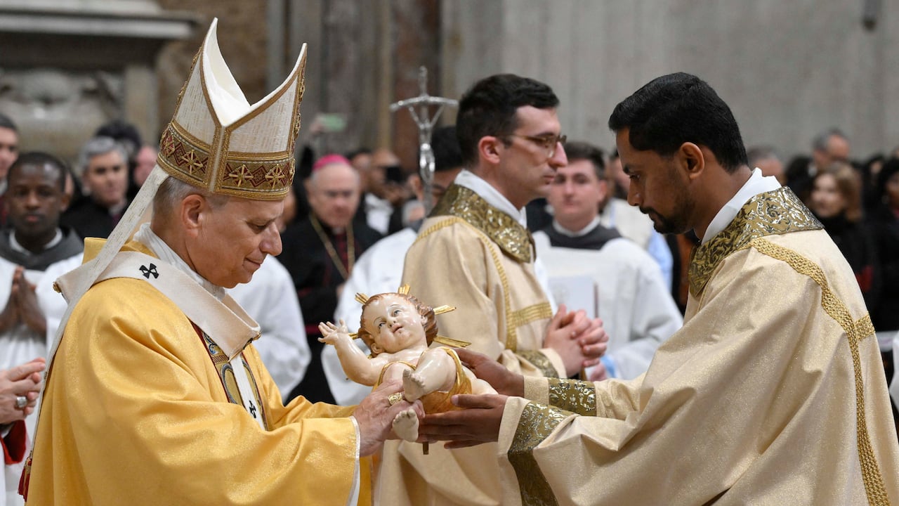Esta fotografía proporcionada el 24 de diciembre de 2025 por Vatican Media muestra al Papa León XIV recibiendo la estatua del Niño Jesús al final de la misa de Nochebuena en la Basílica de San Pedro en el Vaticano