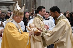 Esta fotografía proporcionada el 24 de diciembre de 2025 por Vatican Media muestra al Papa León XIV recibiendo la estatua del Niño Jesús al final de la misa de Nochebuena en la Basílica de San Pedro en el Vaticano