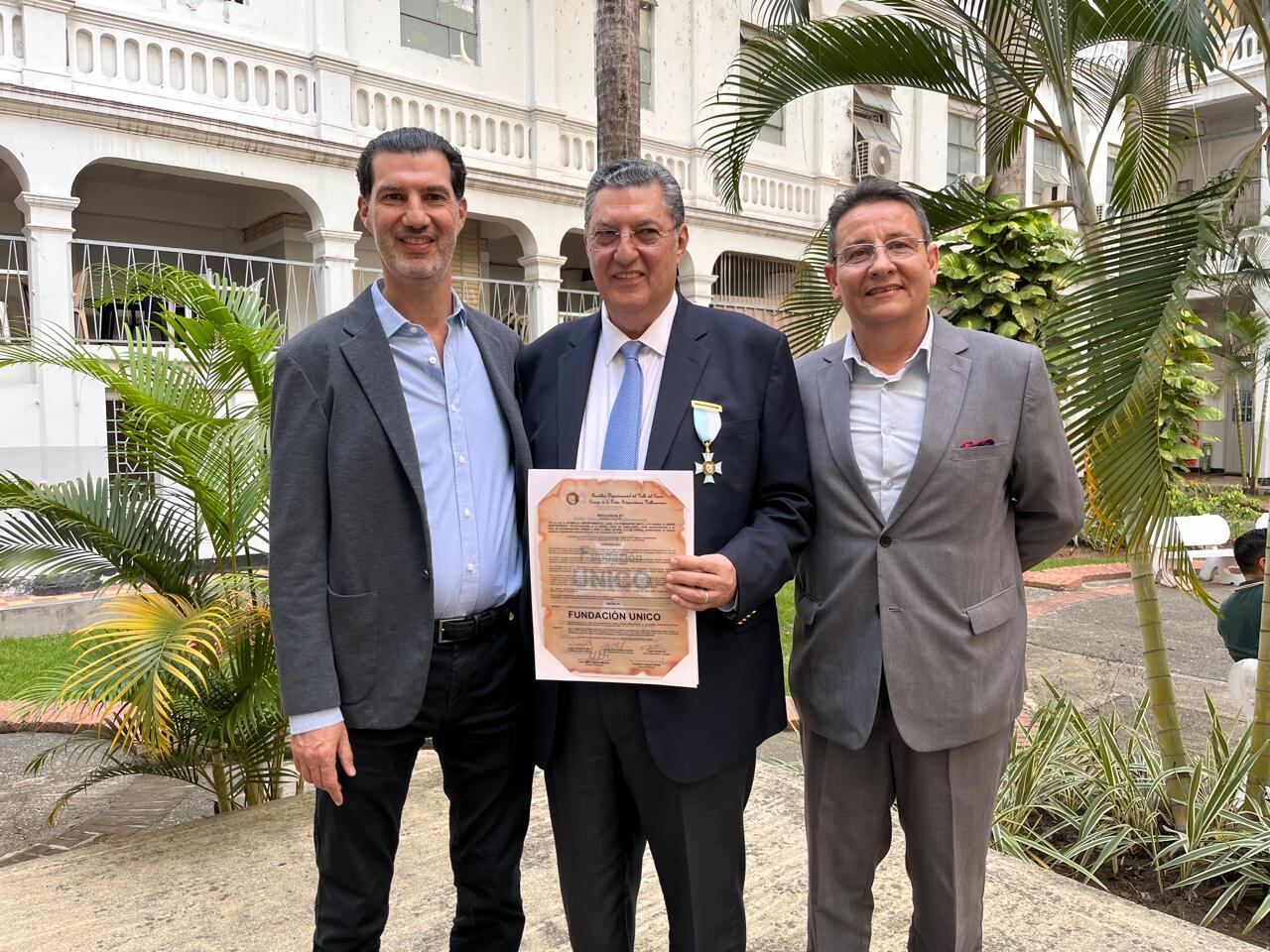 José Toledo Besalel, en el medio, recibe el reconocimiento por el programa After School, que ha beneficiado a miles de niños en Cali y otras ciudades del país. Lo acompañan su hijo David a su izquierda, y el director de la Fundación Unico, Carlos Lara.