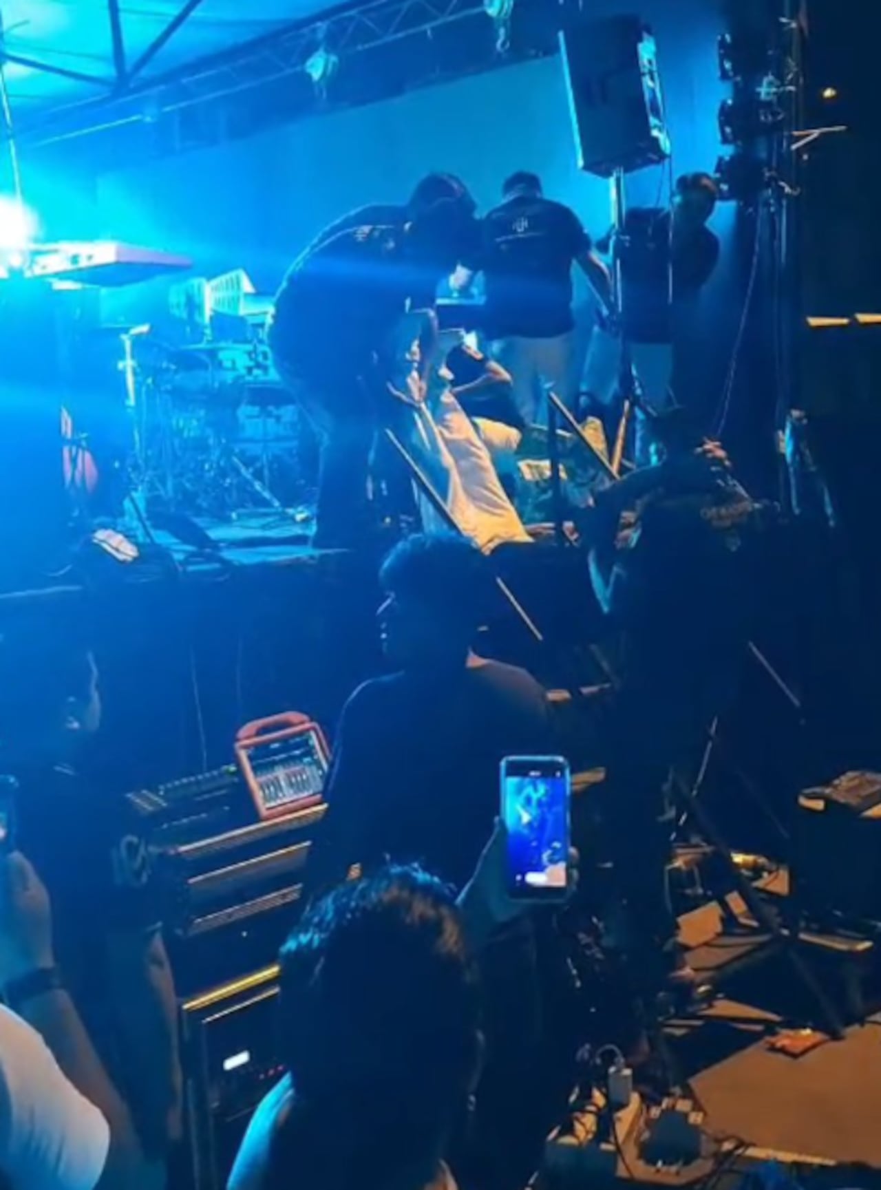 Momento en que sacan del escenario a los dos músicos heridos.