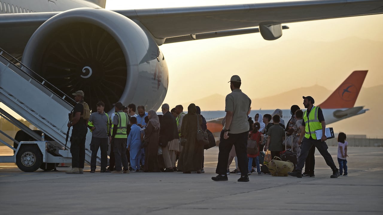 Los pasajeros se preparan para abordar un avión de Qatar Airways en el aeropuerto de Kabul el 9 de septiembre de 2021. - Unos 200 pasajeros, incluidos ciudadanos estadounidenses, salieron del aeropuerto de Kabul el 9 de septiembre de 2021, en el primer vuelo con extranjeros fuera de la capital afgana desde un La evacuación liderada por Estados Unidos terminó el 30 de agosto (Foto de WAKIL KOHSAR / AFP)