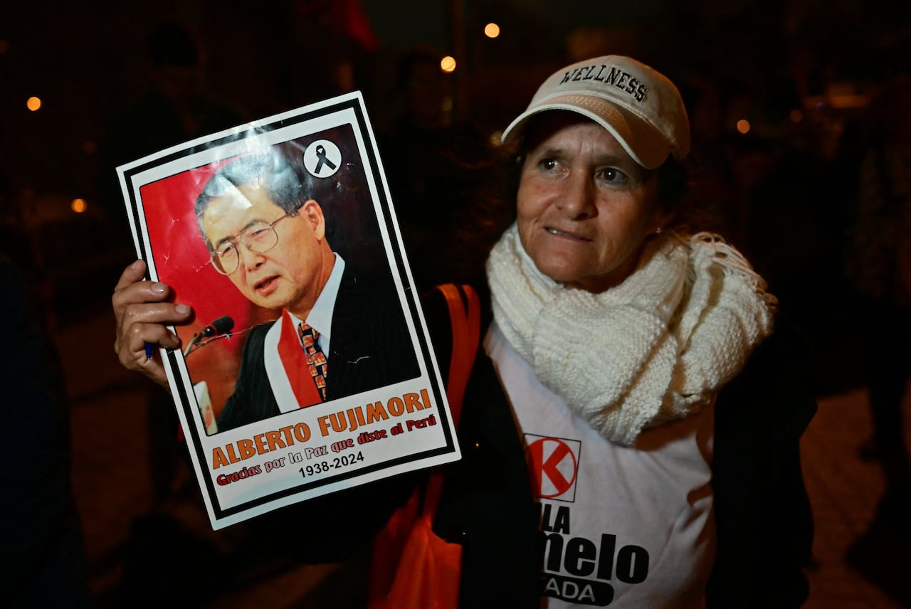Un simpatizante de la candidata presidencial peruana Keiko Fujimori, del partido Fuerza Popular, muestra un retrato del expresidente Alberto Fujimori (1990-2000) durante la segunda vuelta de las elecciones presidenciales en Lima, el 7 de junio de 2026. Los peruanos elegirán a su noveno presidente en 10 años en una reñida segunda vuelta entre la conservadora Keiko Fujimori y el izquierdista Roberto Sánchez, quienes buscan ganarse el voto de electores hartos del caos político y el aumento de la delincuencia. (Foto de MARTIN BERNETTI / AFP)