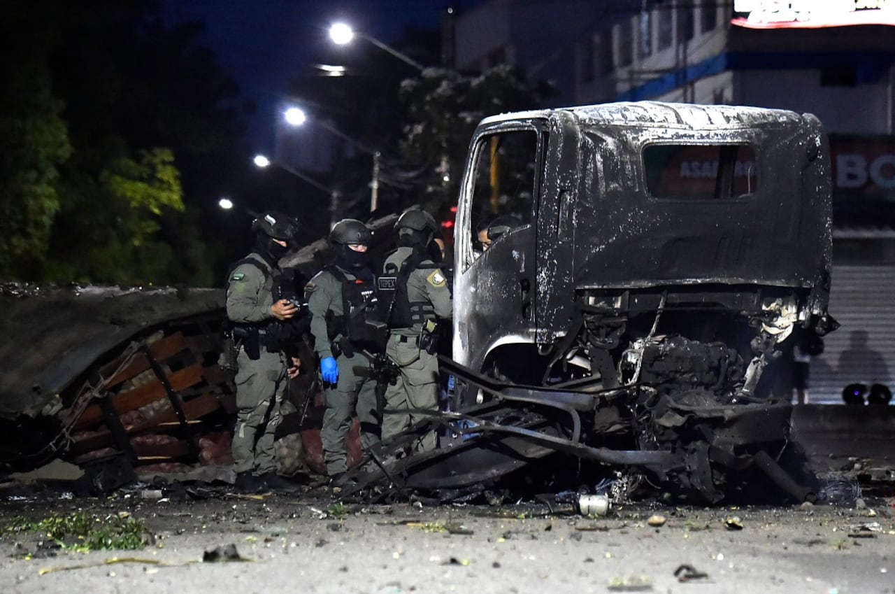 Policías inspeccionan los restos de un camión tras la explosión de un carro bomba en Cúcuta.