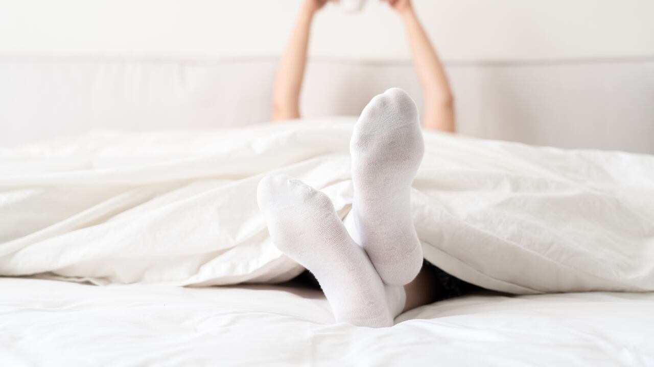 Mantener los pies calientes con medias puede prevenir la incomodidad causada por el frío durante la noche.