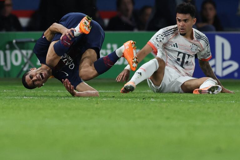 El delantero colombiano del Bayern Munich #14 Luis Díaz (D) taclea al defensor marroquí del Paris Saint-Germain #02 Achraf Hakimi durante la Liga de Campeones de la UEFA.