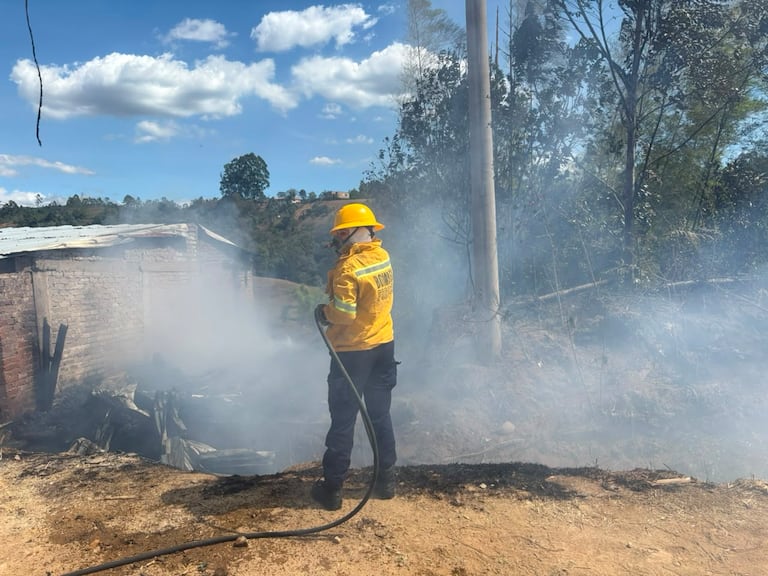 Personal bomberil y miembros del grupo scout de emergencia despliegan mangueras para refrigerar con agua el área afectada en el sector de Pueblillo, logrando proteger viviendas aledañas y líneas de energía.