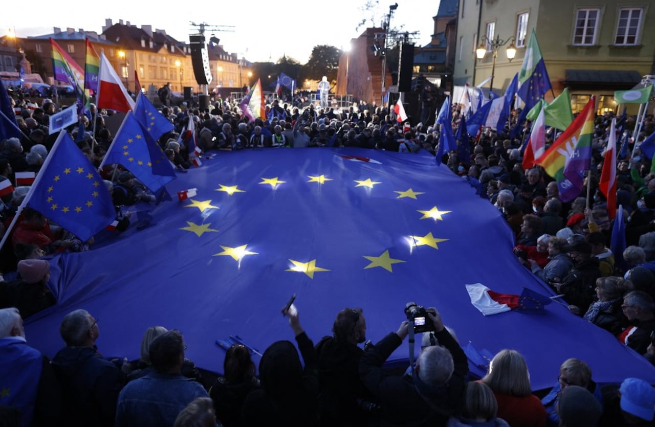 Los participantes sostienen una gran bandera de la UE mientras participan en una manifestación a favor de la UE tras un fallo del Tribunal Constitucional contra la primacía de la legislación de la UE en Polonia, en Varsovia el 10 de octubre de 2021. (Photo by Wojtek RADWANSKI / AFP)