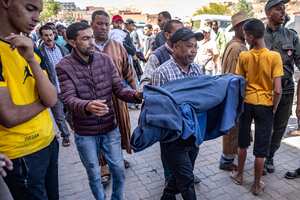 A man carries the blanket-wrapped body of a victim killed in an earthquake in Moulay Brahim, Al Haouz province, on September 9, 2023. Morocco's deadliest earthquake in decades has killed at least 1000 people, officials said on September 9, causing widespread damage and sending terrified residents and tourists scrambling to safety in the middle of the night. (Photo by FADEL SENNA / AFP)
