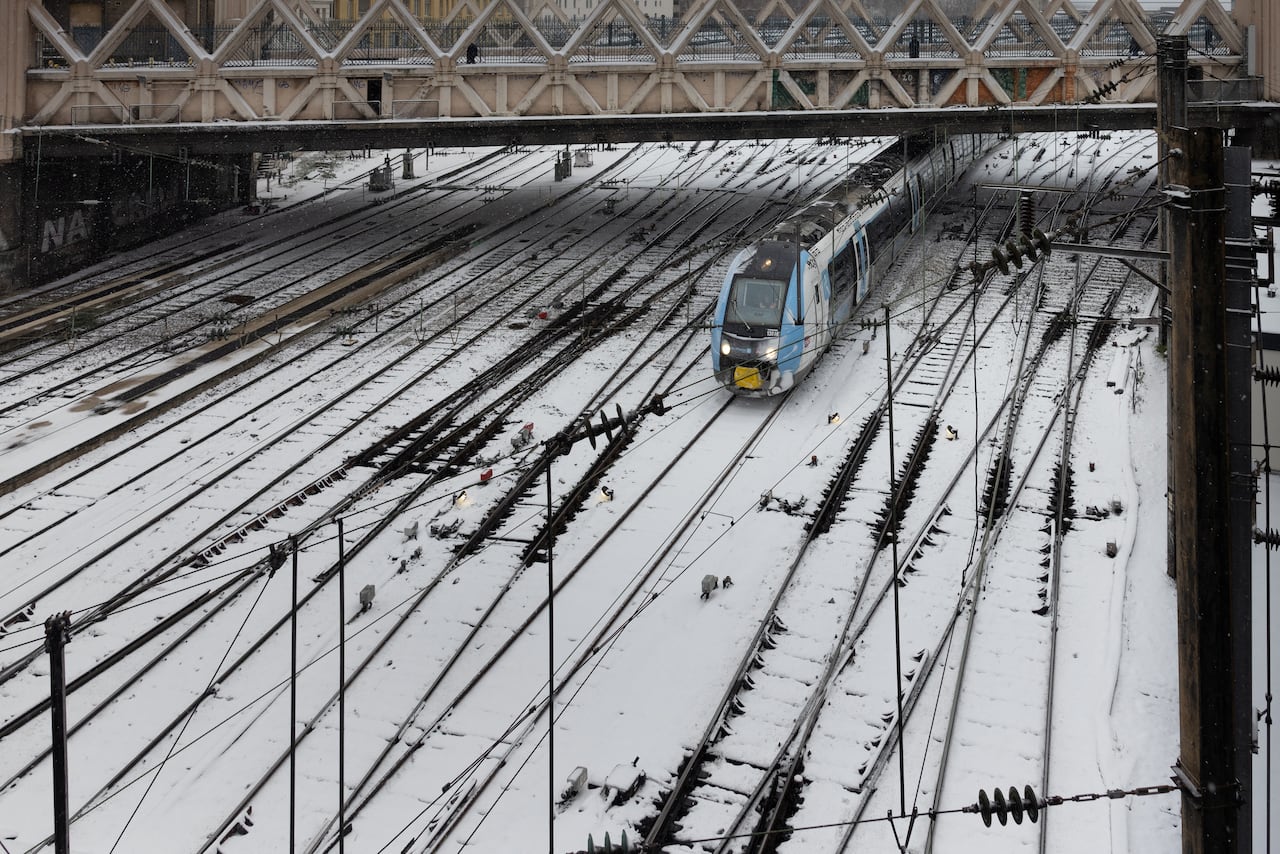 Un Tren Regional Exprés (TER) sale de la estación Gare de l'Est durante una tormenta de nieve en París, el 7 de enero de 2026.
