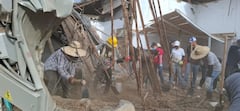 Un grupo de muchachos golpea con porras los muros que quedaron en pie tras el temblor.
