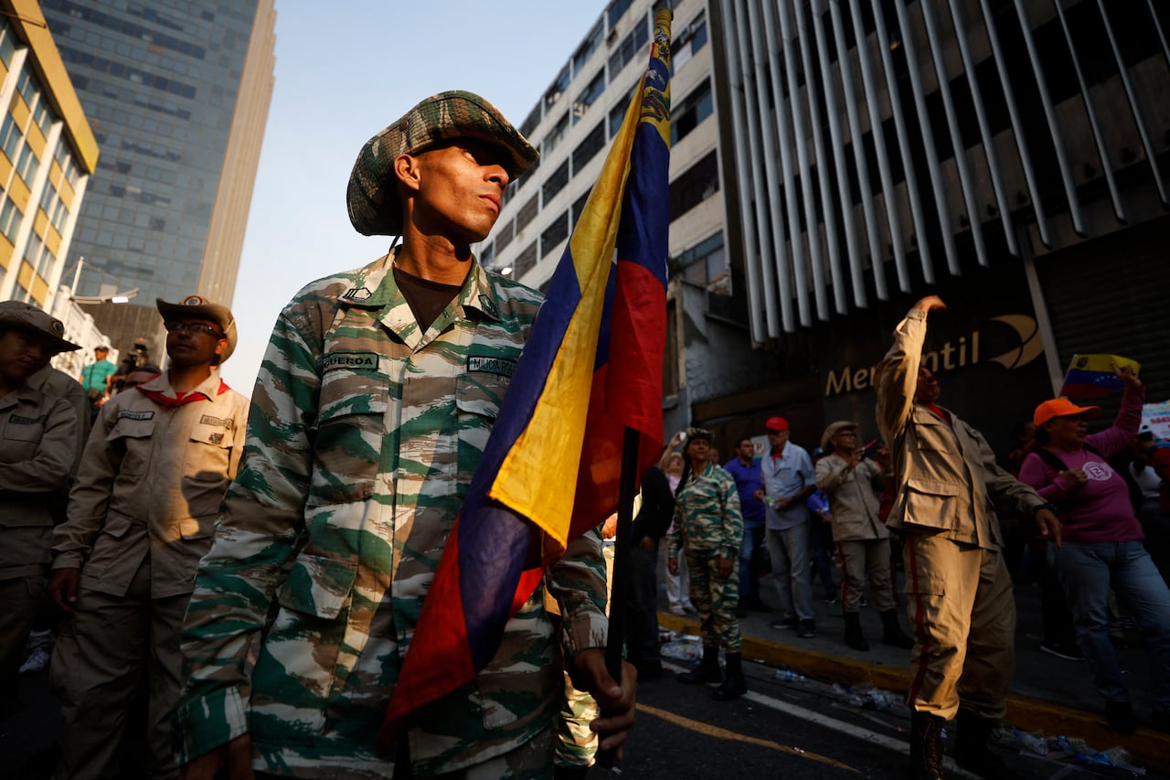 Miembros de la Milicia Nacional Bolivariana participan en una marcha en apoyo a los migrantes venezolanos deportados de Estados Unidos a El Salvador en Caracas el 25 de marzo de 2025. (Foto de Pedro MATTEY / AFP)