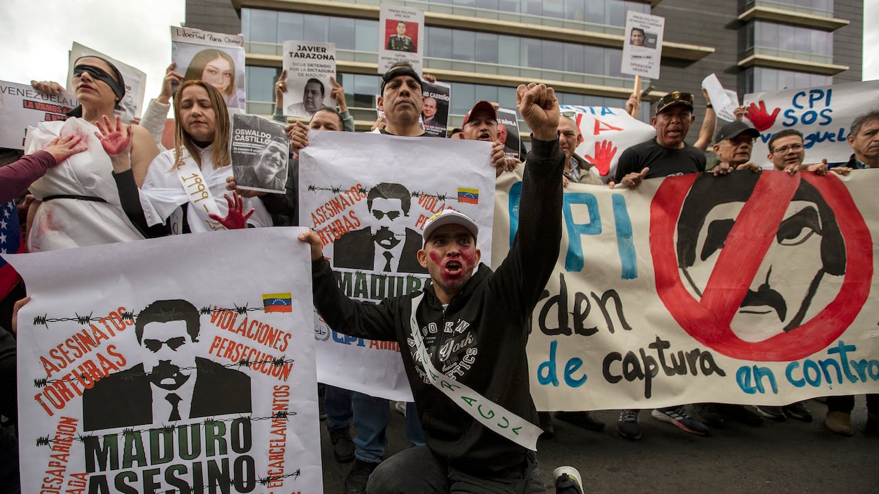 Manifestantes sostienen carteles contra el gobierno del presidente venezolano Nicolás Maduro durante una manifestación en Bogotá el 1 de diciembre de 2024