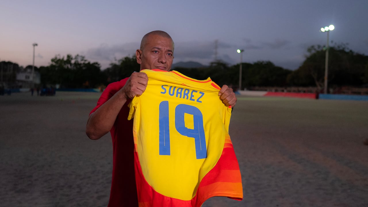 Javier Suárez, padre del futbolista colombiano Luis Javier Suárez, sostiene la camiseta de su hijo en Santa Marta, departamento de Magdalena, Colombia, el 15 de abril de 2026. (Foto de Luis ACOSTA / AFP)