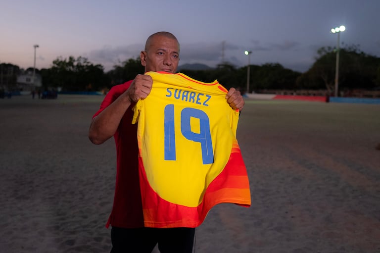 Javier Suárez, padre del futbolista colombiano Luis Javier Suárez, sostiene la camiseta de su hijo en Santa Marta, departamento de Magdalena, Colombia, el 15 de abril de 2026. (Foto de Luis ACOSTA / AFP)