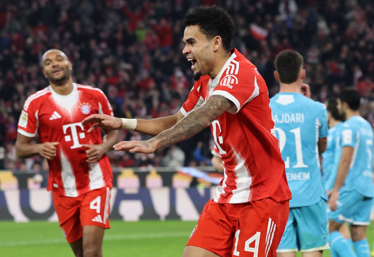 El delantero colombiano #14 del Bayern Múnich, Luis Díaz (der.), celebra el 4-1 durante el partido de la Bundesliga alemana entre el FC Bayern Múnich y el TSG 1899 Hoffenheim en Múnich, sur de Alemania, el 8 de febrero de 2026. (Foto de Alexandra BEIER / AFP)