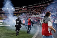 Momento en el que las unidades de seguridad retiran del campo de juego a los hinchas de Santa Fe tras los enfrentamiento con la barra del América.