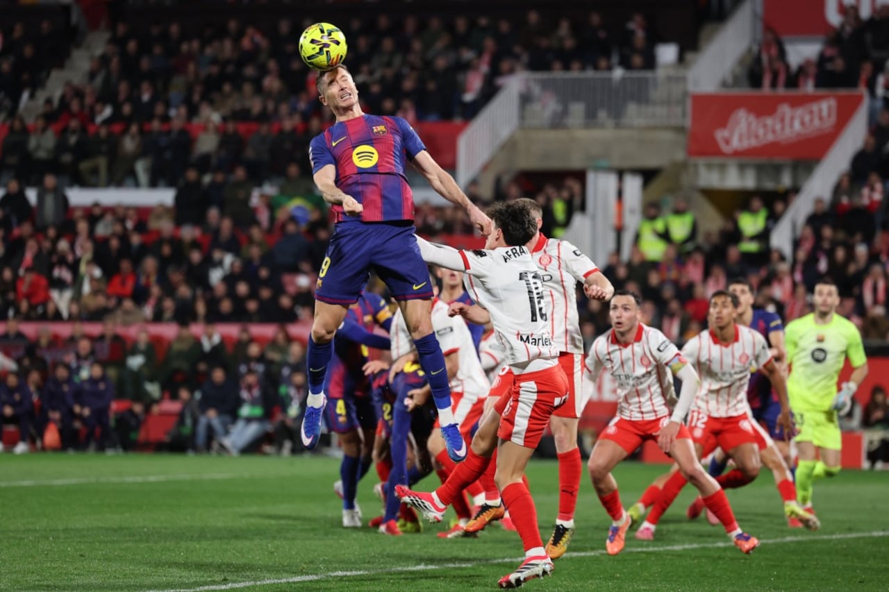 El delantero polaco #09 del Barcelona, Robert Lewandowski, cabecea el balón durante el partido de la liga española entre el Girona FC y el FC Barcelona en el estadio de Montilivi en Girona el 16 de febrero de 2026. (Foto de Josep LAGO / AFP)