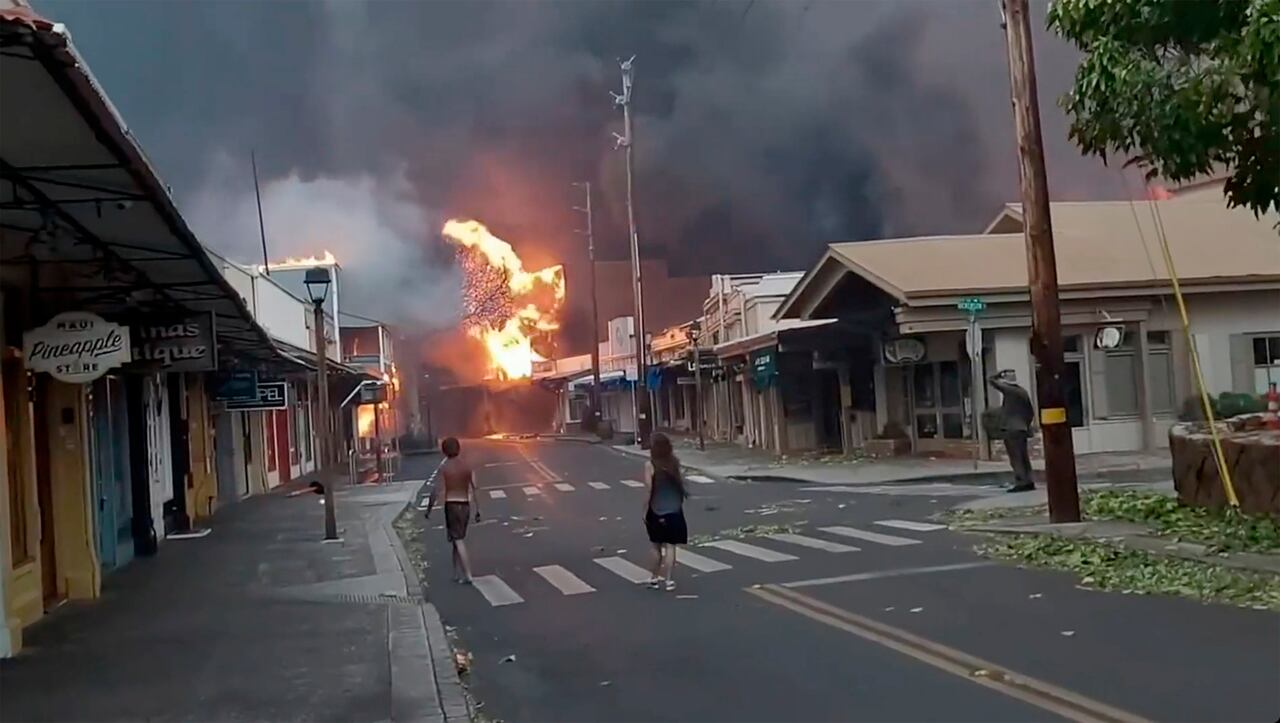 La gente observa cómo el humo y las llamas llenan el aire de los furiosos incendios forestales en Front Street en el centro de Lahaina, Maui, el martes 8 de agosto de 2023. Las autoridades de Maui dicen que los incendios forestales en la histórica ciudad han quemado partes de una de las zonas turísticas más populares en Hawaii.