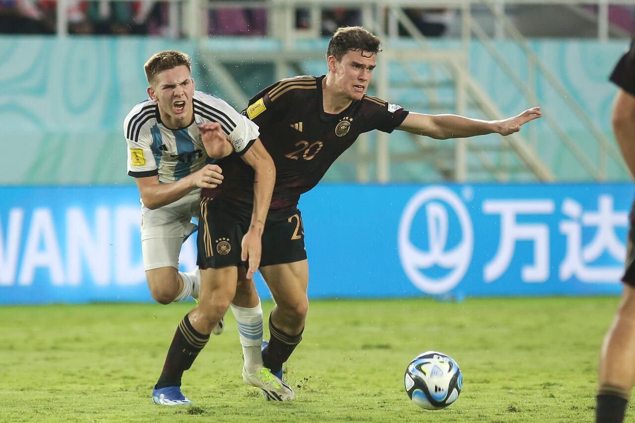 El alemán Robert Ramsak, a la derecha, lucha por el balón contra el argentino Franco Mastantuono durante su partido de semifinales de la Copa Mundial Sub-17 en el estadio Manahan en Surakarta, Java Central, Indonesia, el martes 28 de noviembre de 2023. (Foto AP/John Sumbar)