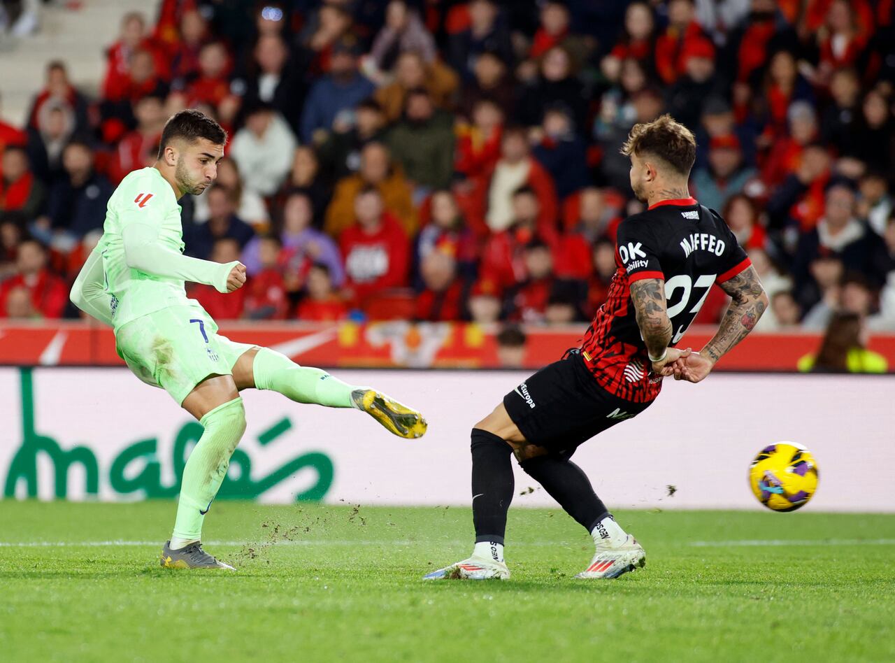 El delantero español del Barcelona #7 Ferran Torres (L) patea el balón junto al defensor español del Real Mallorca #23 Pablo Maffeo.