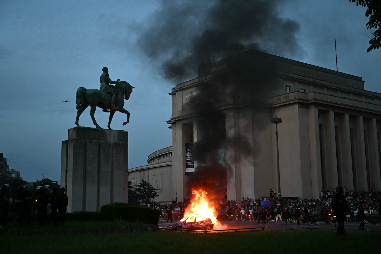 Un coche es incendiado mientras los hinchas del PSG celebran la victoria de su equipo en la final de la Liga de Campeones de la UEFA entre el Paris Saint-Germain (PSG) y el Arsenal FC, disputada en Budapest, en la Plaza del Trocadero de París el 30 de mayo de 2026. (Foto de LOU BENOIST / AFP)