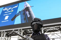 A security personnel officer stands guard in front of a huge image depicting a missile with "Palestine" written on its side, during a rally by supporters of the Iran-backed Houthi movement in solidarity with Iran and Lebanon amid the Middle East war, in the capital Sanaa on April 17, 2026. The Middle East war has created an "unprecedented shock" for the region's economies with no guarantee of a quick recovery, a senior International Monetary Fund official has told AFP. Five of the Gulf's eight oil- and gas-producing countries face a contraction this year, the IMF said in a regional report published on April 16. (Photo by Mohammed HUWAIS / AFP)