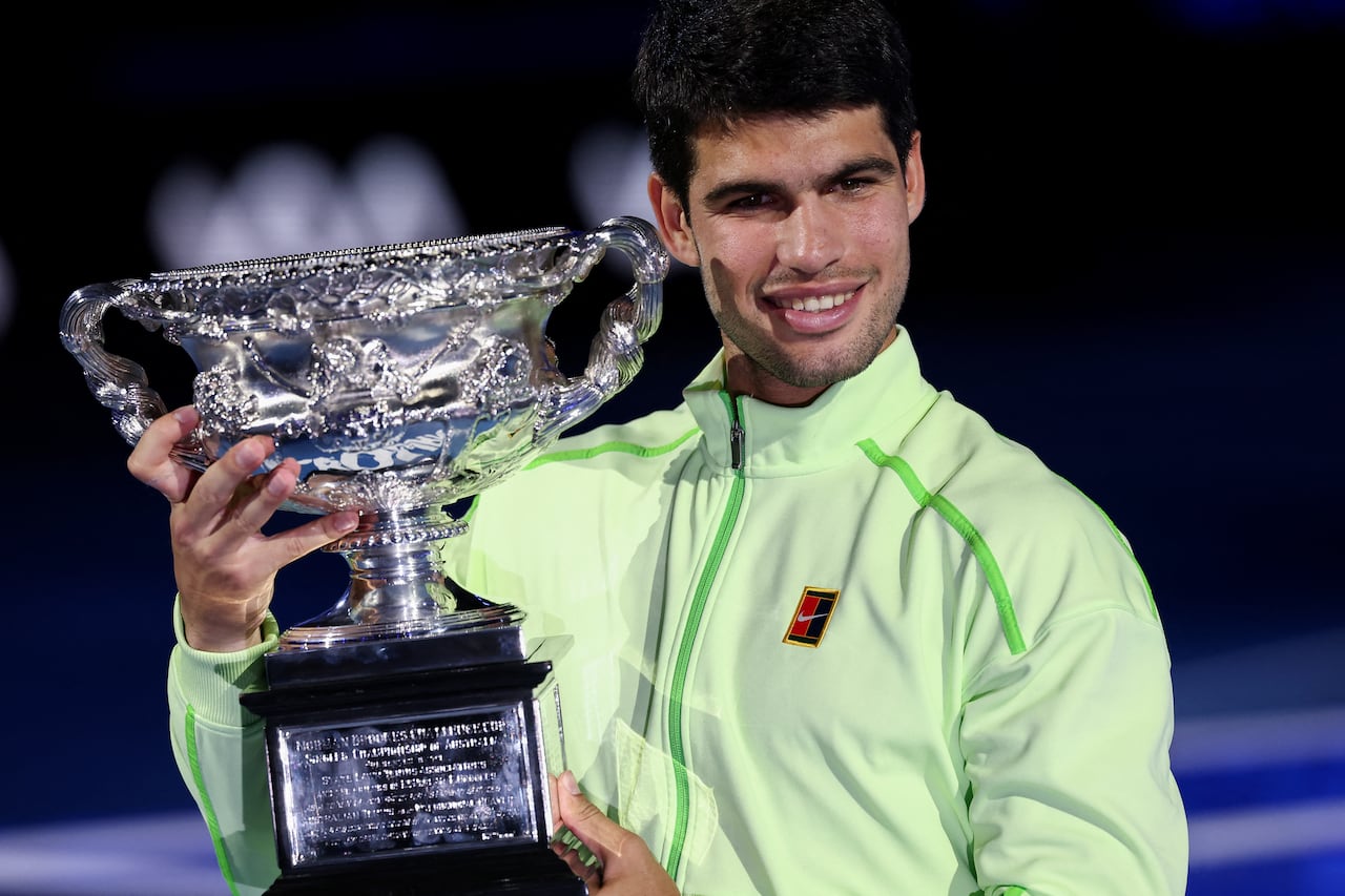 El español Carlos Alcaraz posa con el trofeo tras ganar el Abierto de Australia.