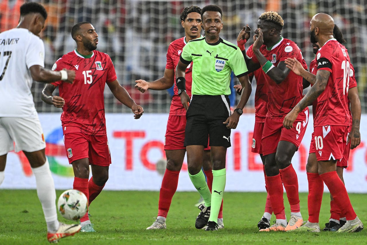 El centrocampista de Guinea Ecuatorial #4 Fede Bikoro (2R) habla con el árbitro somalí Omar Abdulkadir Artan (C) durante el partido de fútbol de octavos de final de la Copa Africana de Naciones (CAN) 2024 entre Guinea Ecuatorial y Guinea en el estadio Alassane Ouattara en Ebimpe, Abidjan, el 28 de enero de 2024.