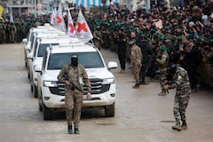 Un combatiente palestino de Hamas precede a los vehículos de la Cruz Roja Internacional (CICR) cuando llegan a Nuseirat, en el centro de la Franja de Gaza, para recibir a tres rehenes israelíes como parte del séptimo intercambio de rehenes-prisioneros el 22 de febrero de 2025. Tres rehenes israelíes más fueron liberados por militantes de Hamas en una ceremonia en el centro de Gaza el 22 de febrero, después de que otros dos fueron liberados en la parte sur del territorio palestino. (Foto de Bashar TALEB / AFP)