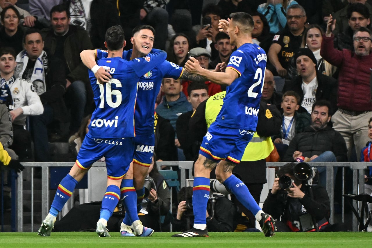 El delantero uruguayo del Getafe, Martín Satriano (centro), celebra el primer gol del partido de la liga española entre el Real Madrid y el Getafe en el estadio Santiago Bernabéu de Madrid el 2 de marzo de 2026. (Foto de Javier SORIANO / AFP)