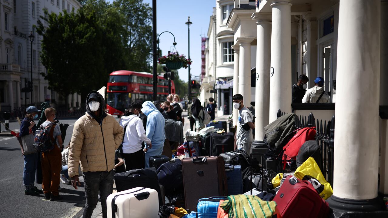 Un grupo de inmigrantes con su equipaje organiza una protesta frente a su alojamiento en el oeste de Londres el 2 de junio de 2023, mientras se quejan de las condiciones de vida.