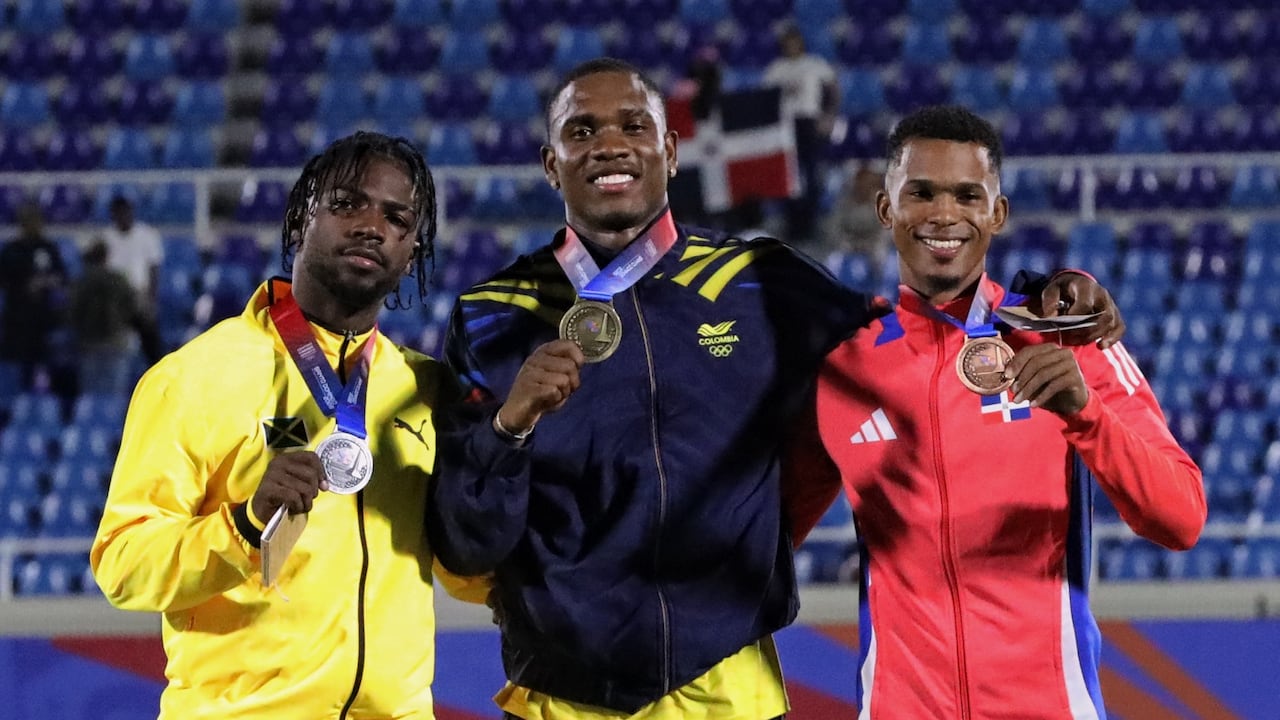 Ronal Longa (centro) al alcanzar la medalla de oro de los 100 metros planos de atletismo de los Juegos Centroamericanos y del Caribe 2026.