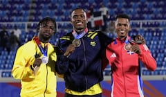 Ronal Longa (centro) al alcanzar la medalla de oro de los 100 metros planos de atletismo de los Juegos Centroamericanos y del Caribe 2026.
