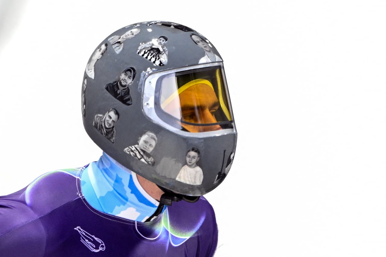 El ucraniano Vladyslav Heraskevych lleva un casco con la imagen de deportistas ucranianos durante el entrenamiento masculino de skeleton en el Centro de Deslizamiento de Cortina durante los Juegos Olímpicos de Invierno de Milán Cortina 2026 en Cortina d'Ampezzo el 10 de febrero de 2026. El Comité Olímpico Internacional (COI) declaró el 10 de febrero que un corredor ucraniano de skeleton podía llevar un brazalete negro en los Juegos Olímpicos de Invierno, pero confirmó que había prohibido su casco, que representa a deportistas ucranianos caídos en la guerra con Rusia. (Foto de Tiziana FABI / AFP)