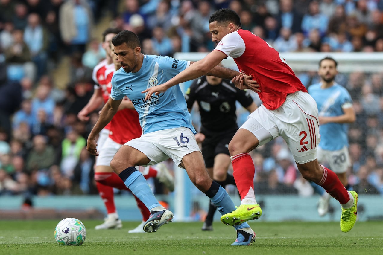 El defensa francés del Arsenal, William Saliba (derecha), disputa el balón con el centrocampista español del Manchester City, Rodri (izquierda), durante el partido de la Premier League inglesa entre el Manchester City y el Arsenal en el Etihad Stadium de Manchester, al noroeste de Inglaterra, el 19 de abril de 2026. (Foto de Darren Staples / AFP)