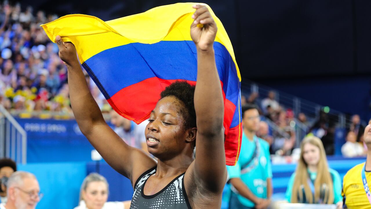 Rentería celebrando la medalla de bronce con la bandera de Colombia.