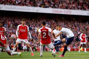 Richarlison, del Tottenham, a la derecha, intenta un tiro a portería durante el partido de fútbol de la Liga Premier inglesa entre Arsenal y Tottenham Hotspur en el estadio Emirates de Londres, Inglaterra, el domingo 24 de septiembre de 2023. (Foto AP/David Cliff)