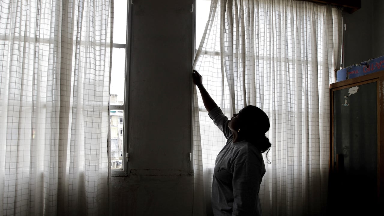 A Foreign domestic worker closes the curtains