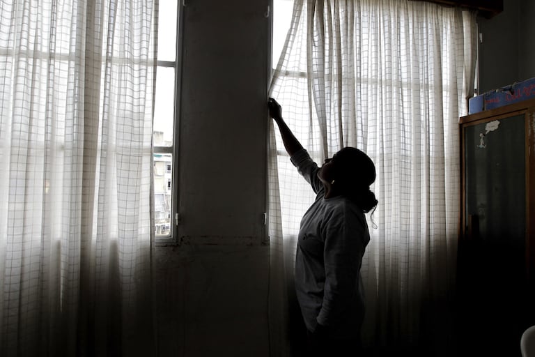 A Foreign domestic worker closes the curtains