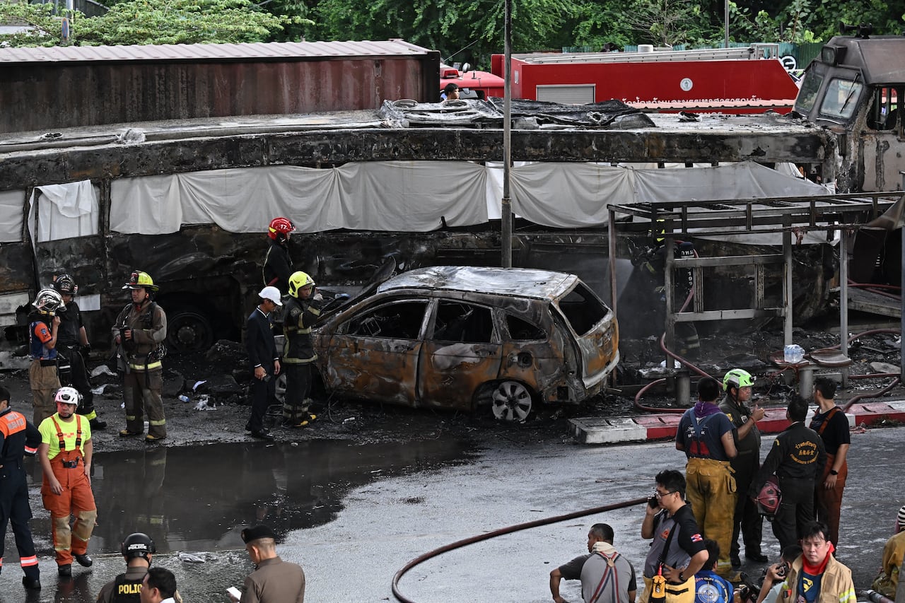 Bomberos y rescatistas rodean la zona afectada por la colisión de un tren con un autobús bajo la estación de tren del aeropuerto de Makkasan en Bangkok, el 16 de mayo de 2026. (Foto de Lillian SUWANRUMPHA / AFP)