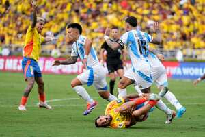 Colombia's Daniel Munoz, below, grimaces in pain after being fouled by Argentina's Nicolas Otamendi during a qualifying soccer match for the FIFA World Cup 2026 at the Metropolitano Roberto Melendez stadium in Barranquilla, Colombia, Tuesday, Sept. 10, 2024. (AP Photo/Ricardo Mazalan)