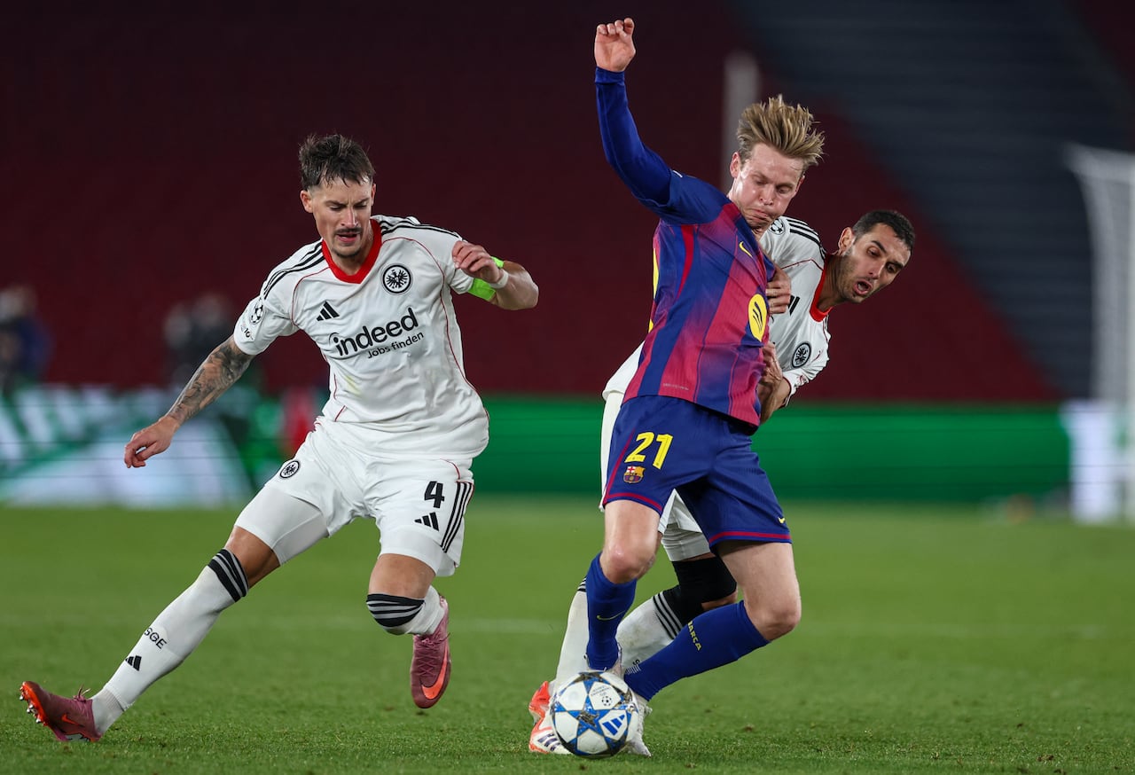 (L-R) Frankfurt's German defender #04 Robin Koch, Barcelona's Dutch midfielder #21 Frenkie De Jong and Frankfurt's Tunisian midfielder #15 Ellyes Skhiri vie for the ball during the UEFA Champions League league phase day 6 football match between FC Barcelona and Eintracht Frankfurt at Camp Nou Stadium in Barcelona on December 9, 2025. (Photo by Josep LAGO / AFP)