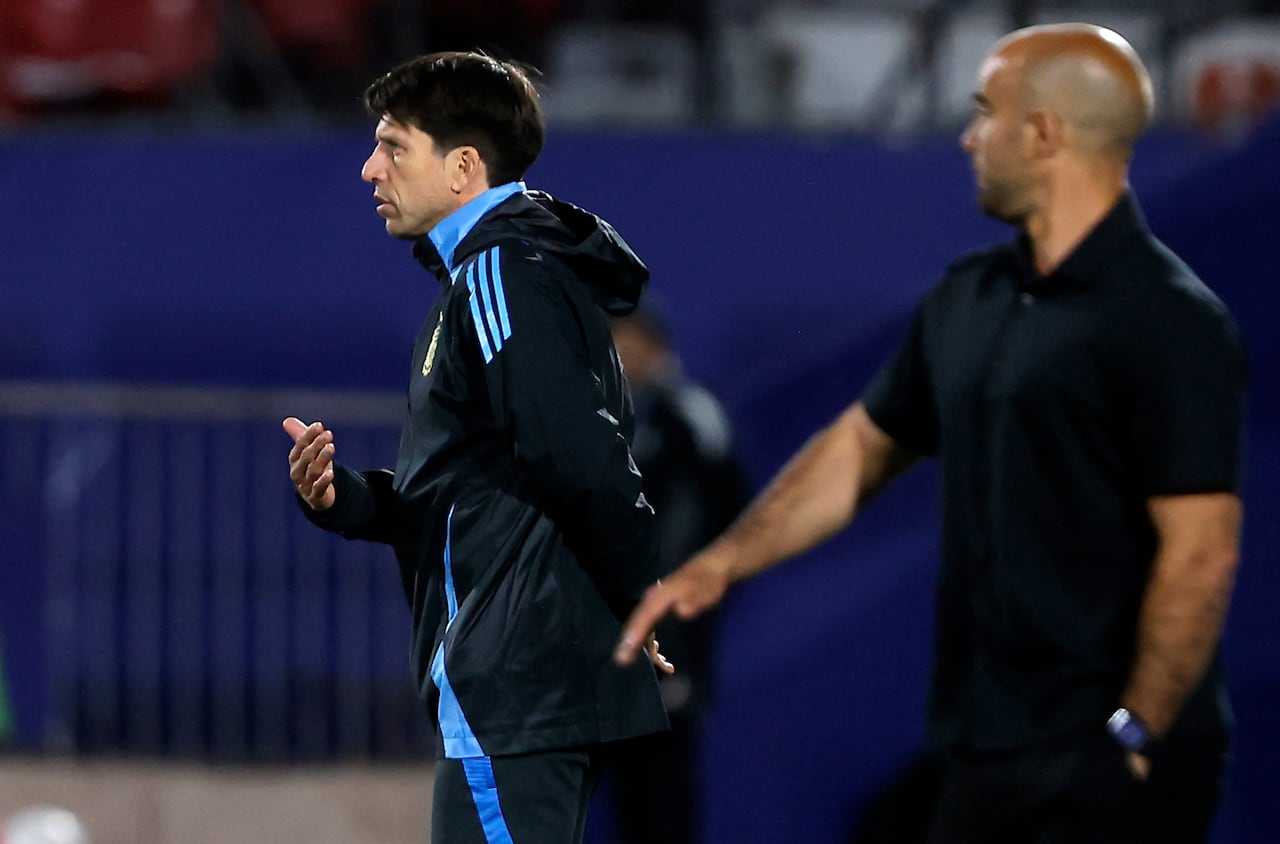 El entrenador de Argentina, Diego Placente, hace un gesto junto al entrenador de México, Eduardo Arce, durante el partido de cuartos de final de la Copa Mundial Sub-20 de la FIFA 2025 entre México y Argentina en el Estadio Nacional de Santiago el 11 de octubre de 2025. (Foto de Raúl BRAVO / AFP)