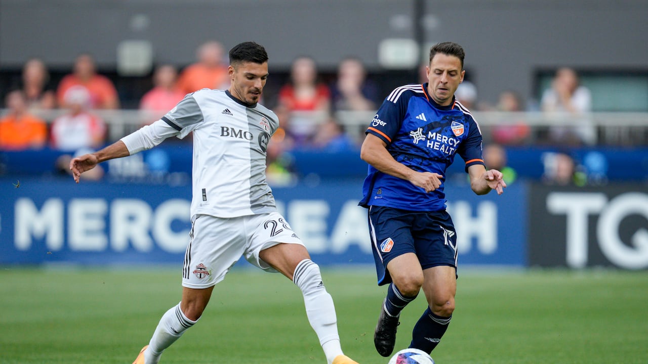 El defensa de Toronto FC Raoul Petretta (28) y Santiago Arias (13) de FC Cincinnati compiten por el balón durante la primera mitad de un partido de fútbol de la MLS el miércoles 21 de junio de 2023 en Cincinnati. (Foto AP/Jeff Dean)