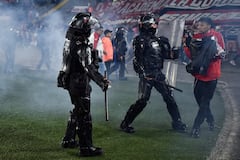 Momento en el que las unidades de seguridad retiran del campo de juego a los hinchas de Santa Fe tras los enfrentamiento con la barra del América.