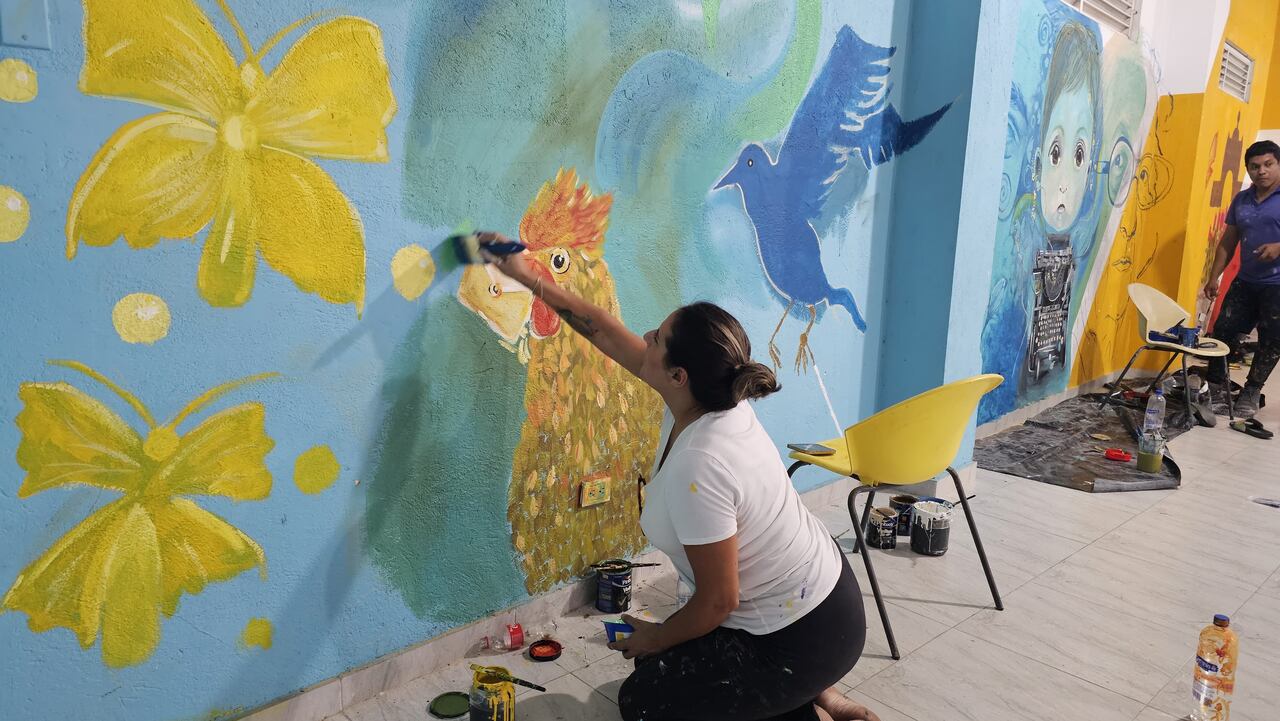 La artista Liliana Martínez pintando las mariposas amarillas en un mural inspirado en Gabo y en su Macondo, en la Casa del Telegrafista, en Aracataca.