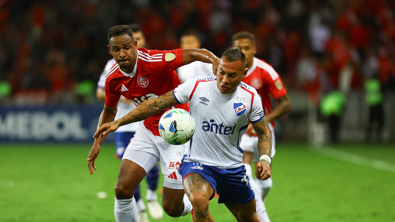 El mediocampista del Internacional #05 Fernando y el delantero chileno del Nacional #17 Eduardo Vargas luchan por el balón durante el partido de fútbol de la fase de grupos de la Copa Libertadores entre el Internacional de Brasil y el Nacional de Uruguay en el estadio Beira Rio en Porto Alegre, Brasil, el 22 de abril de 2025. (Foto de SILVIO AVILA / AFP)